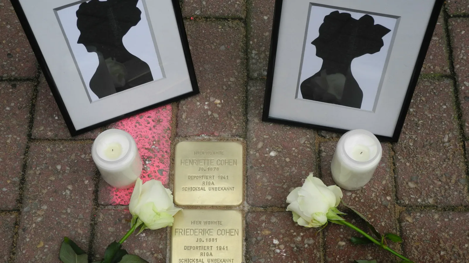 Stolpersteine mit Kerzen und Scherenschnitten