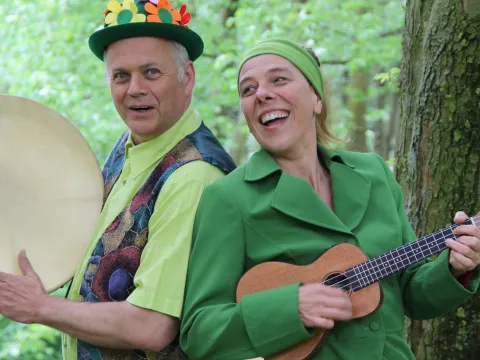Musiker und Musikerin unter einem Baum