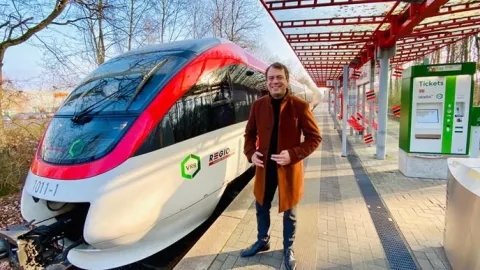 Bürgermeister steht auf dem Bahnsteig an der Regiobahn S28