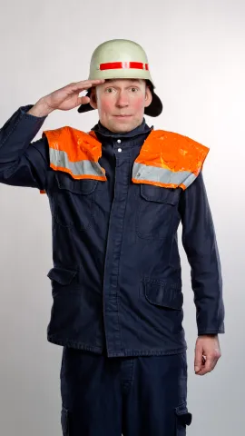 Mann in Feuerwehruniform salutiert
