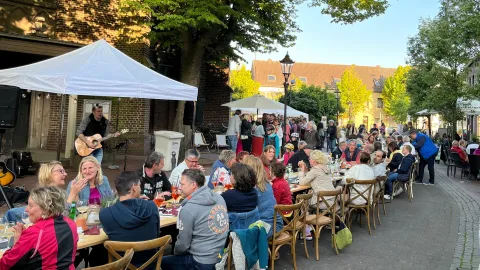 Menschen an langen Tischen in der Einkaufszone