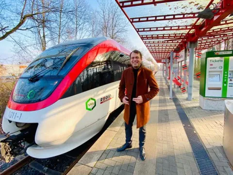 Bürgermeister steht auf dem Bahnsteig an der Regiobahn S28