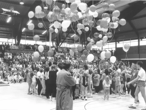 Große Gruppe von Menschen, die Luftballons steigen lässt