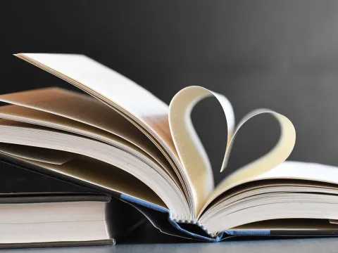 Aufgeklapptes Buch mit zwei zu einem Herz gefaltenen Seiten