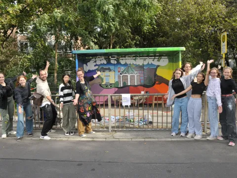 Schülergruppe mit Lehrer und Künstler vor Projekt  