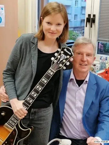 Die Musikerin Natalie Wallrath und der Autor Jean Lasalle schauen lächelnd in die Kamera